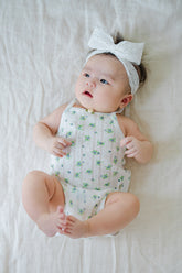 Avauma Summer Picot Sleeveless Bodysuit Blue Garden Mint. Adorable baby wearing a white floral print romper with a delicate bow headband.
